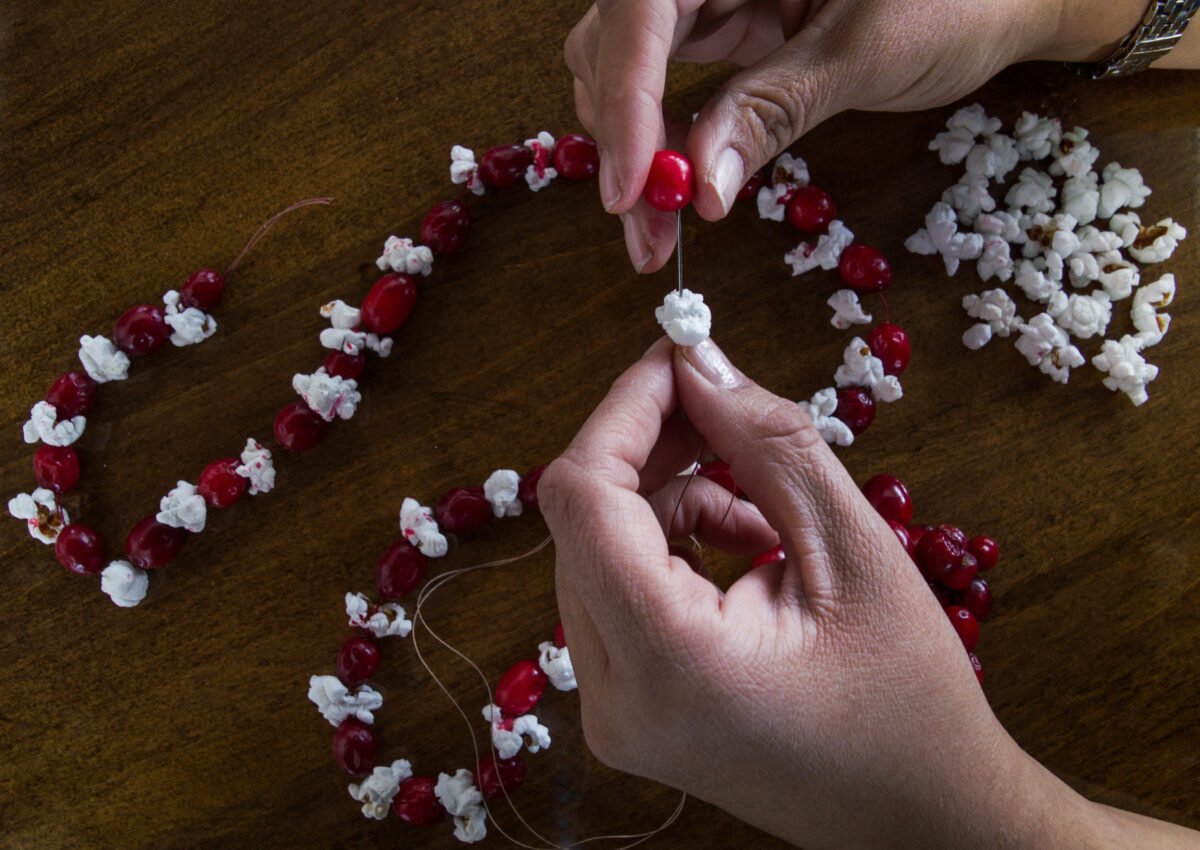 stringing cranberries and popcorn for a chicken christmas wreath
