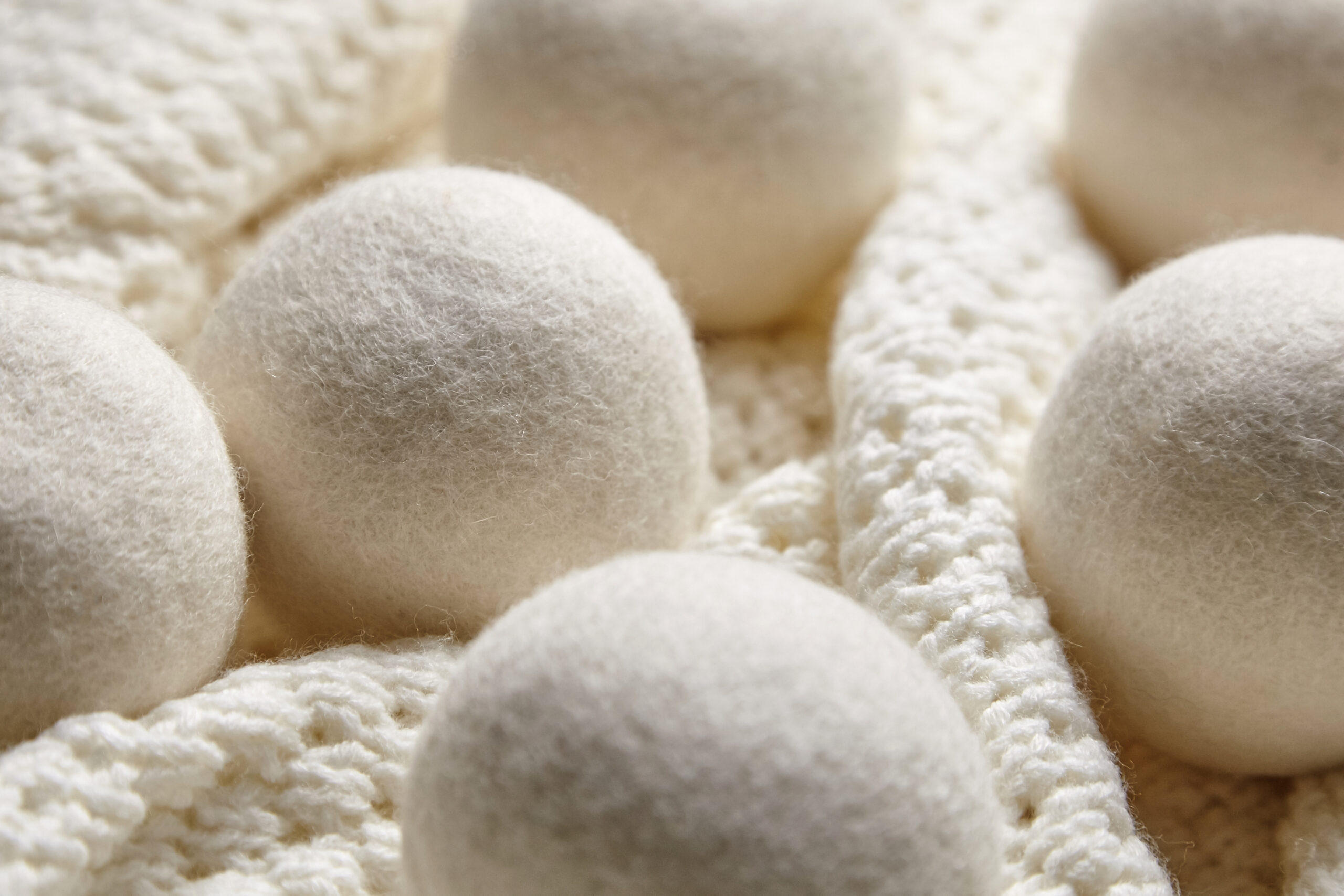white felted dryer balls on a blanket